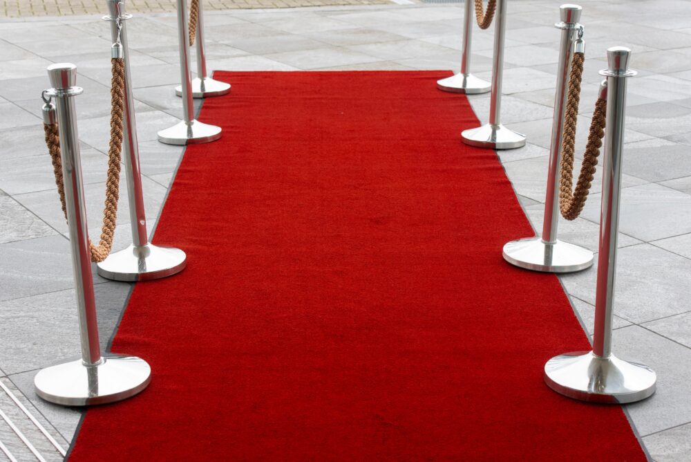 Empty red carpet steps at a film festival at dusk, spotlights and photographers barriers, no people, cinematic