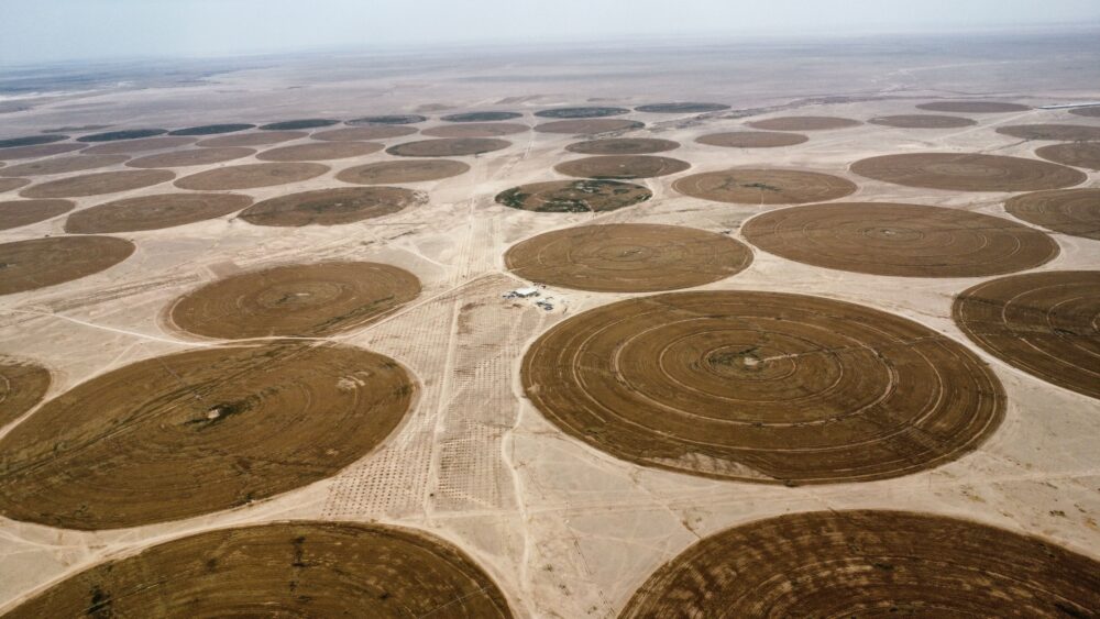 Aerial view of a large data center building with cooling systems in a dry arid landscape, South America